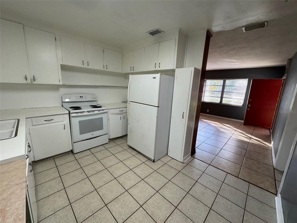 4023 Southwest 20th Street Gainesville, FL 32608 - Photo 2 of 10 a kitchen with a stove a refrigerator and cabinets