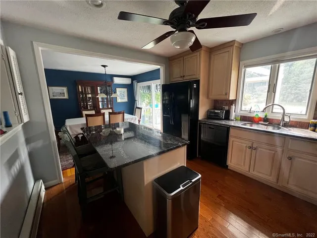 a kitchen with stainless steel appliances kitchen island granite countertop a sink stove and refrigerator