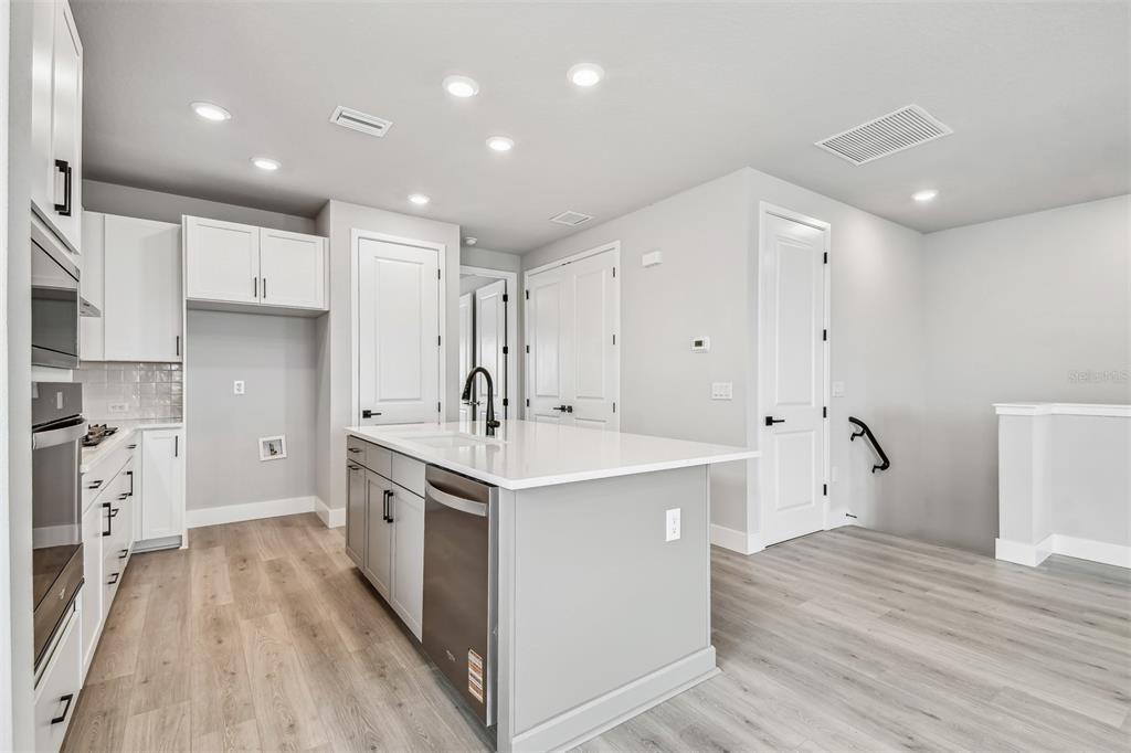 1631 Springwell Lane Sarasota, FL 34240 - Photo 11 of 43 a kitchen with white cabinets appliances and sink