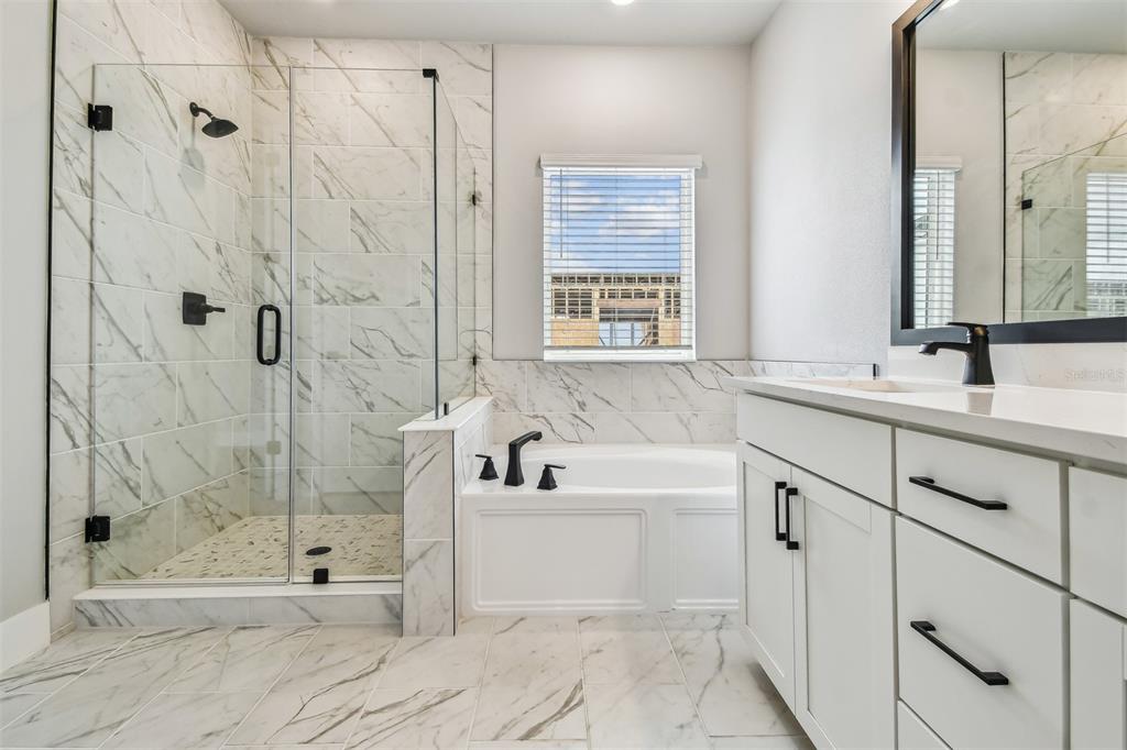 1631 Springwell Lane Sarasota, FL 34240 - Photo 26 of 43 a bathroom with a tub sink shower and mirror