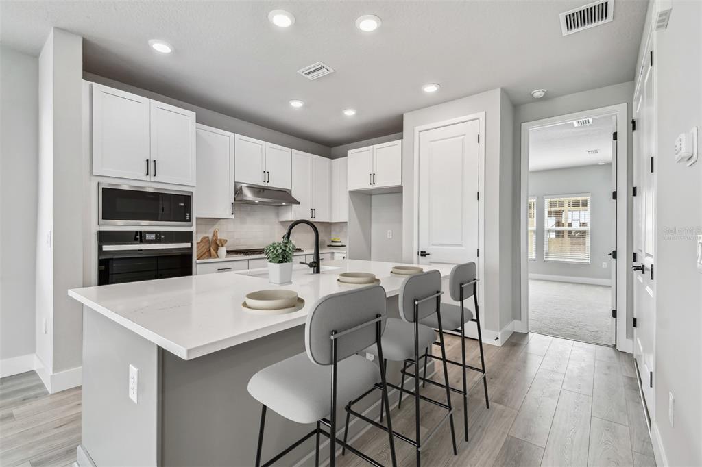 1631 Springwell Lane Sarasota, FL 34240 - Photo 8 of 43 a kitchen with stainless steel appliances a table chairs refrigerator and sink