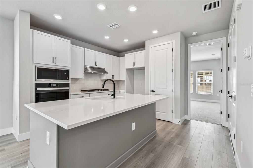 1631 Springwell Lane Sarasota, FL 34240 - Photo 9 of 43 a kitchen with stainless steel appliances granite countertop a sink stove and refrigerator