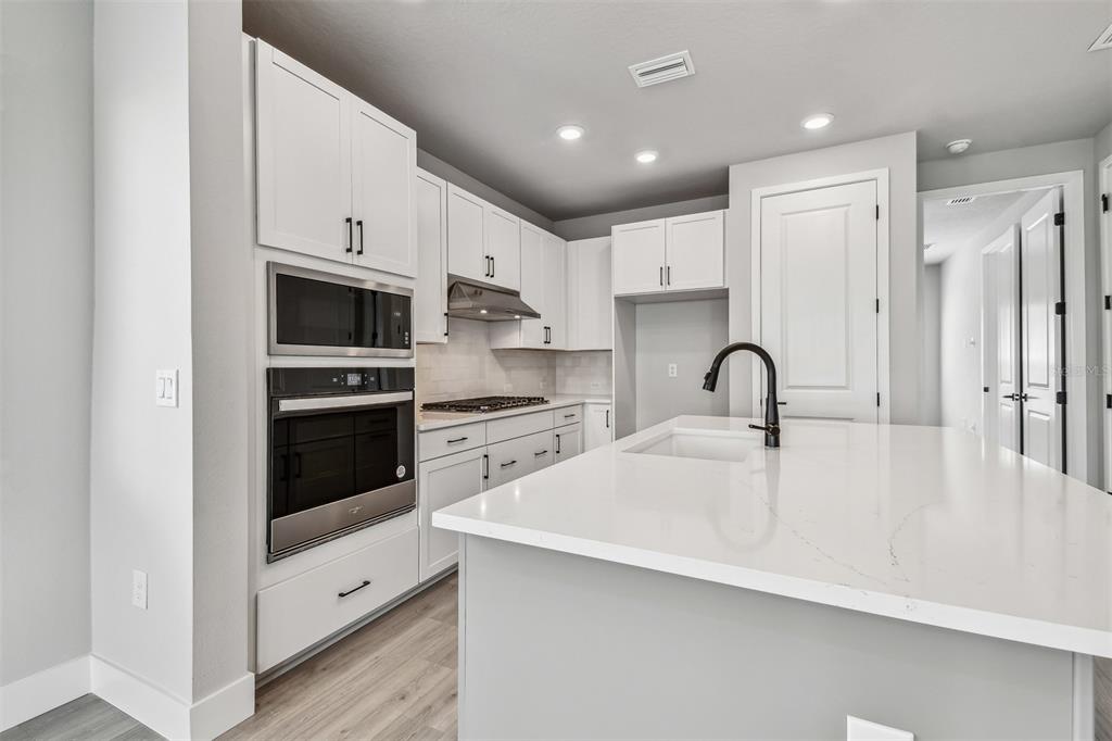1631 Springwell Lane Sarasota, FL 34240 - Photo 10 of 43 a large white kitchen with stainless steel appliances
