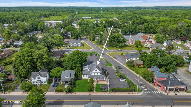 an aerial view of residential houses with outdoor space and trees