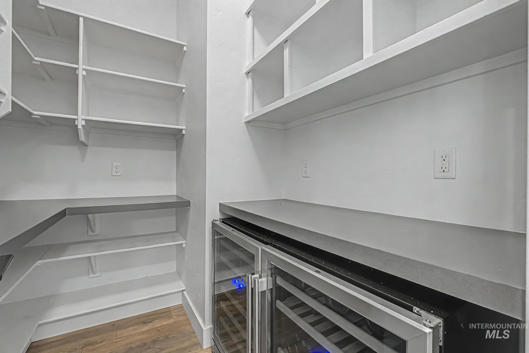 6521 South Pemberley Way Meridian, ID 83642 - Photo 20 of 42 Pantry with extensive white shelving, grey countertops, and wood-finish flooring