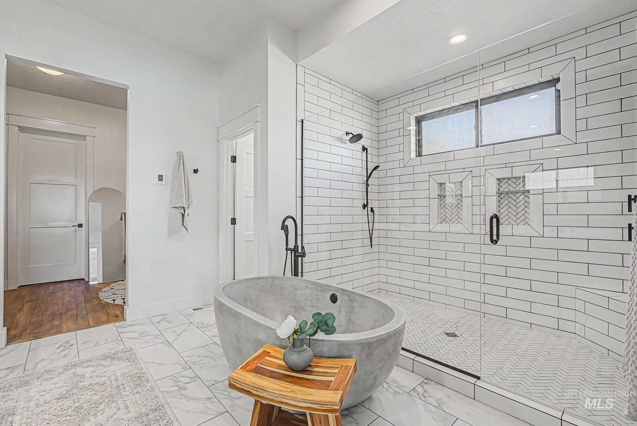 6521 South Pemberley Way Meridian, ID 83642 - Photo 24 of 42 Modern bathroom featuring a freestanding soaking tub with a matte black floor-mounted faucet
