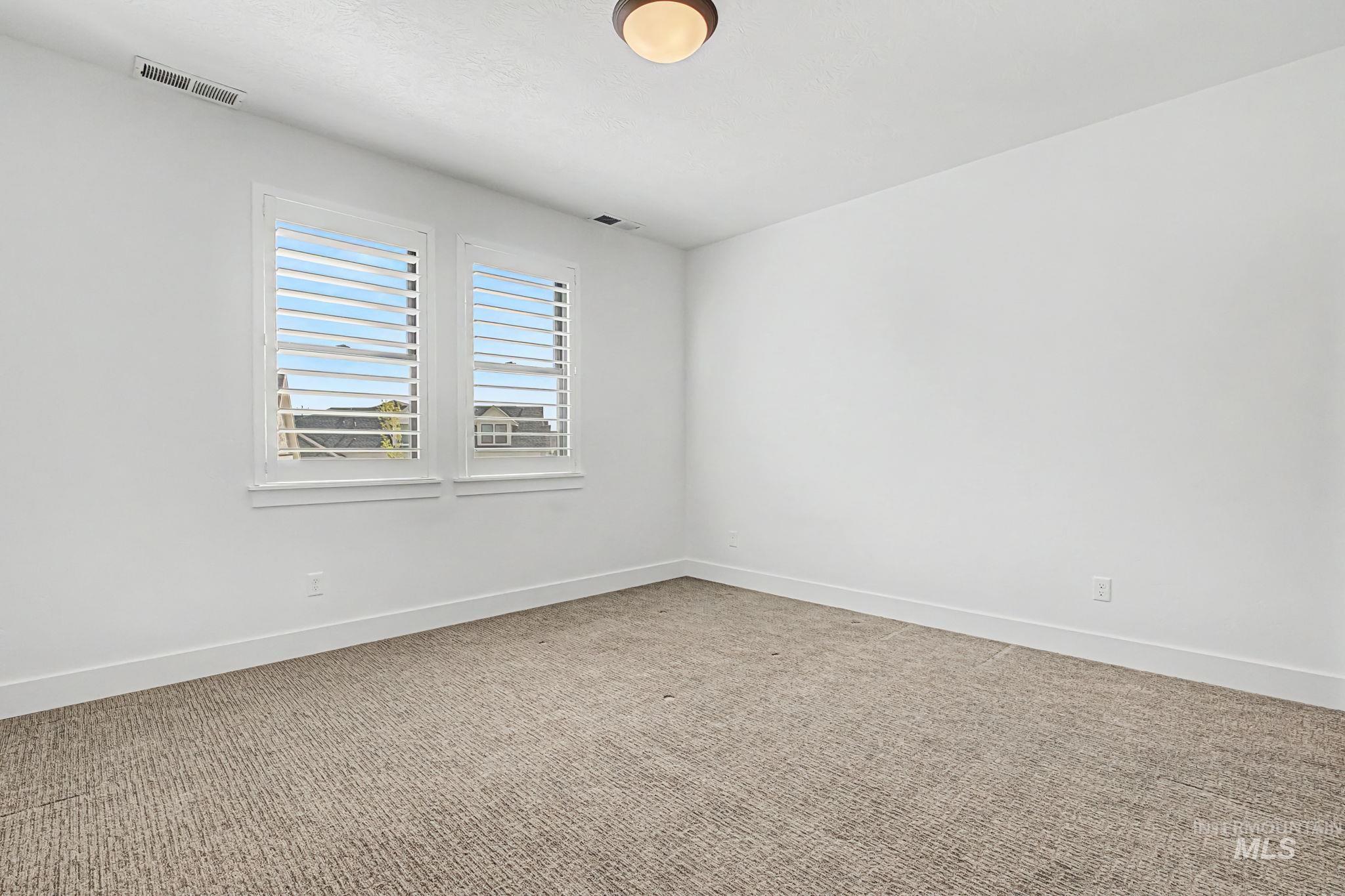 6521 South Pemberley Way Meridian, ID 83642 - Photo 29 of 42 Neutral-toned carpeting paired with white walls, baseboards, and window trim