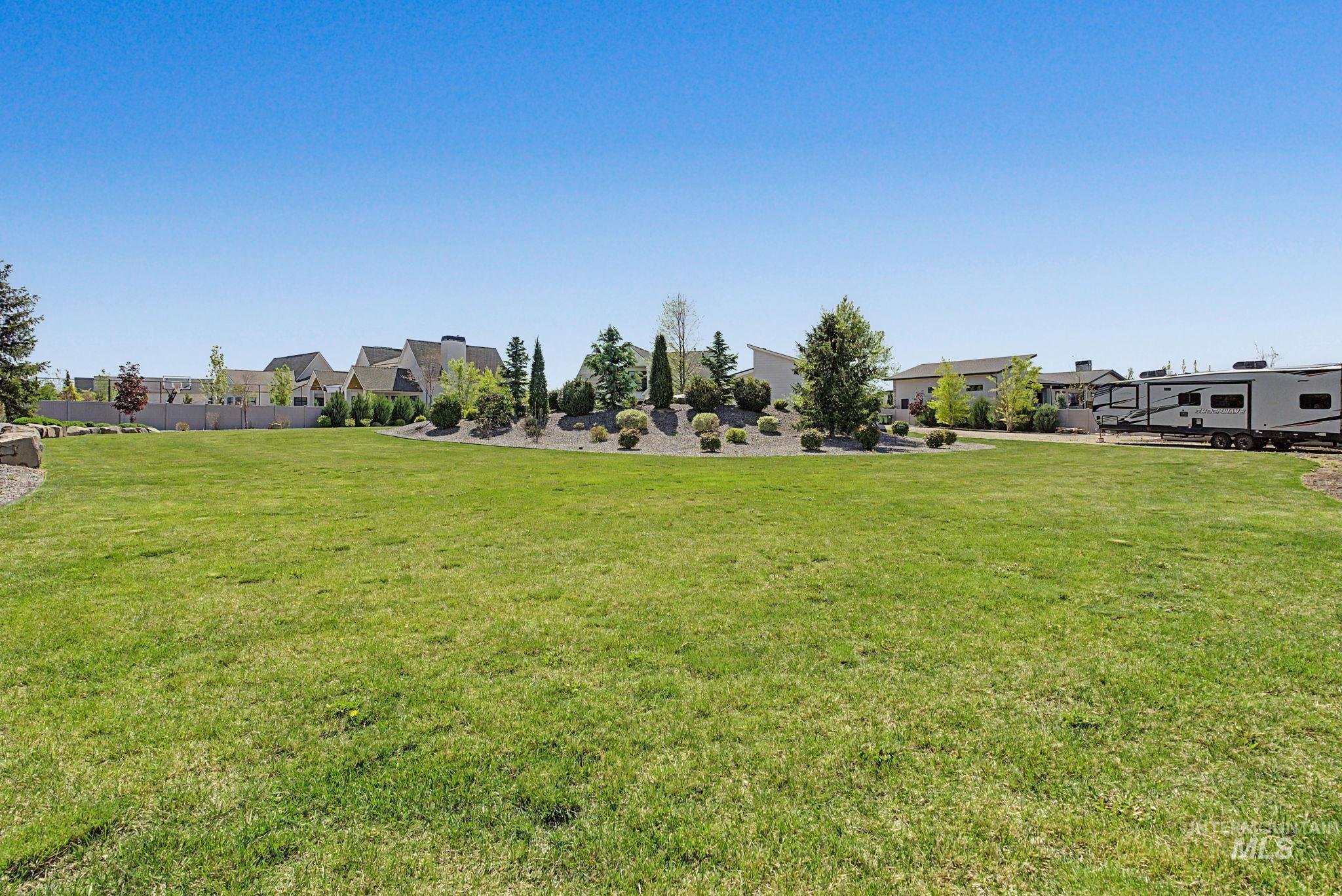 6521 South Pemberley Way Meridian, ID 83642 - Photo 35 of 42 Expansive green lawn with mature landscaping and clear sky overhead