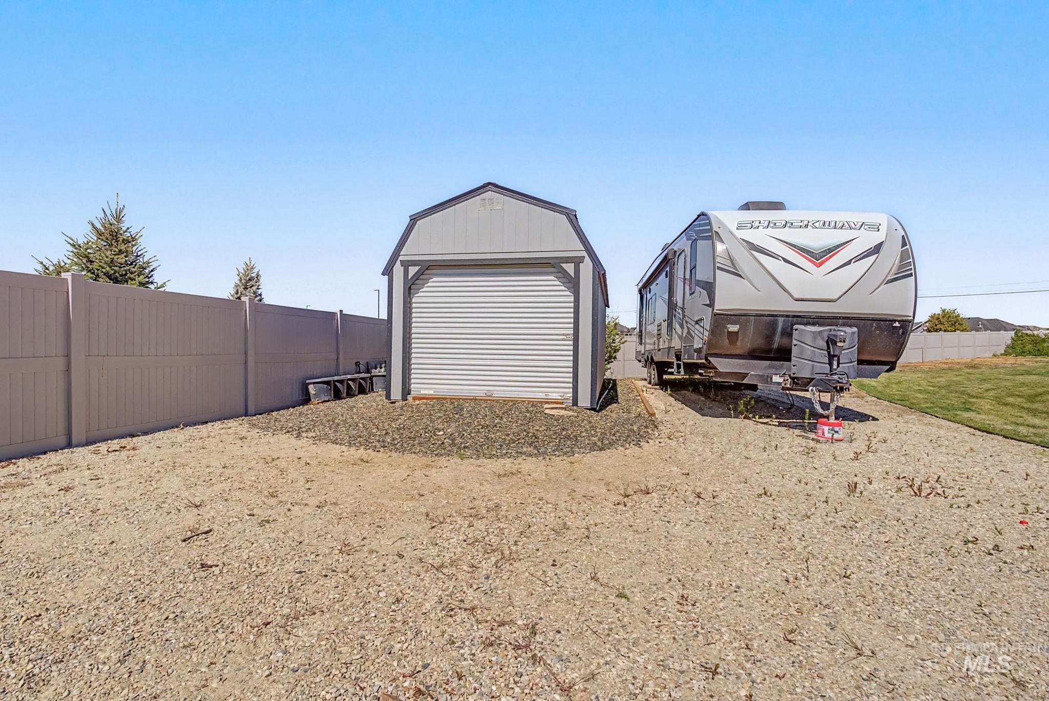 6521 South Pemberley Way Meridian, ID 83642 - Photo 42 of 42 Gravel area featuring a standalone shed with a roll-up door and a dedicated gravel pad