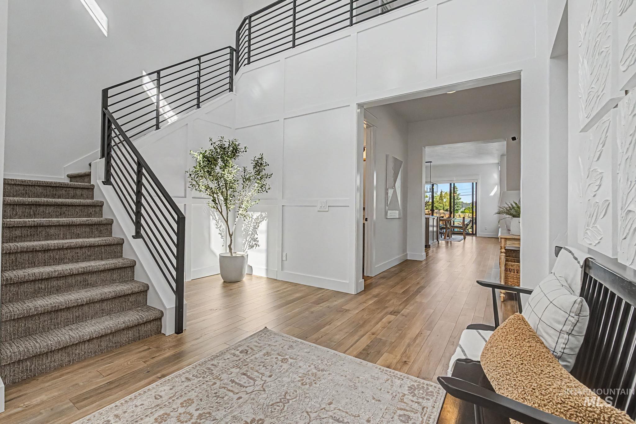6521 South Pemberley Way Meridian, ID 83642 - Photo 5 of 42 Grand entry foyer featuring wood-finish flooring and a carpeted staircase with modern horizontal metal railings