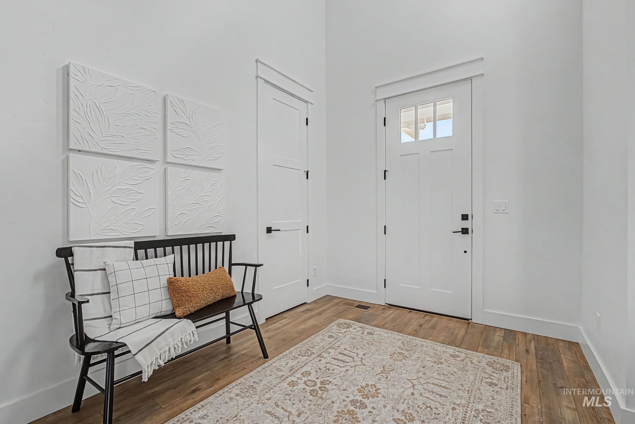 6521 South Pemberley Way Meridian, ID 83642 - Photo 6 of 42 Bright entryway featuring a white paneled door with glass inserts and a matte black handle