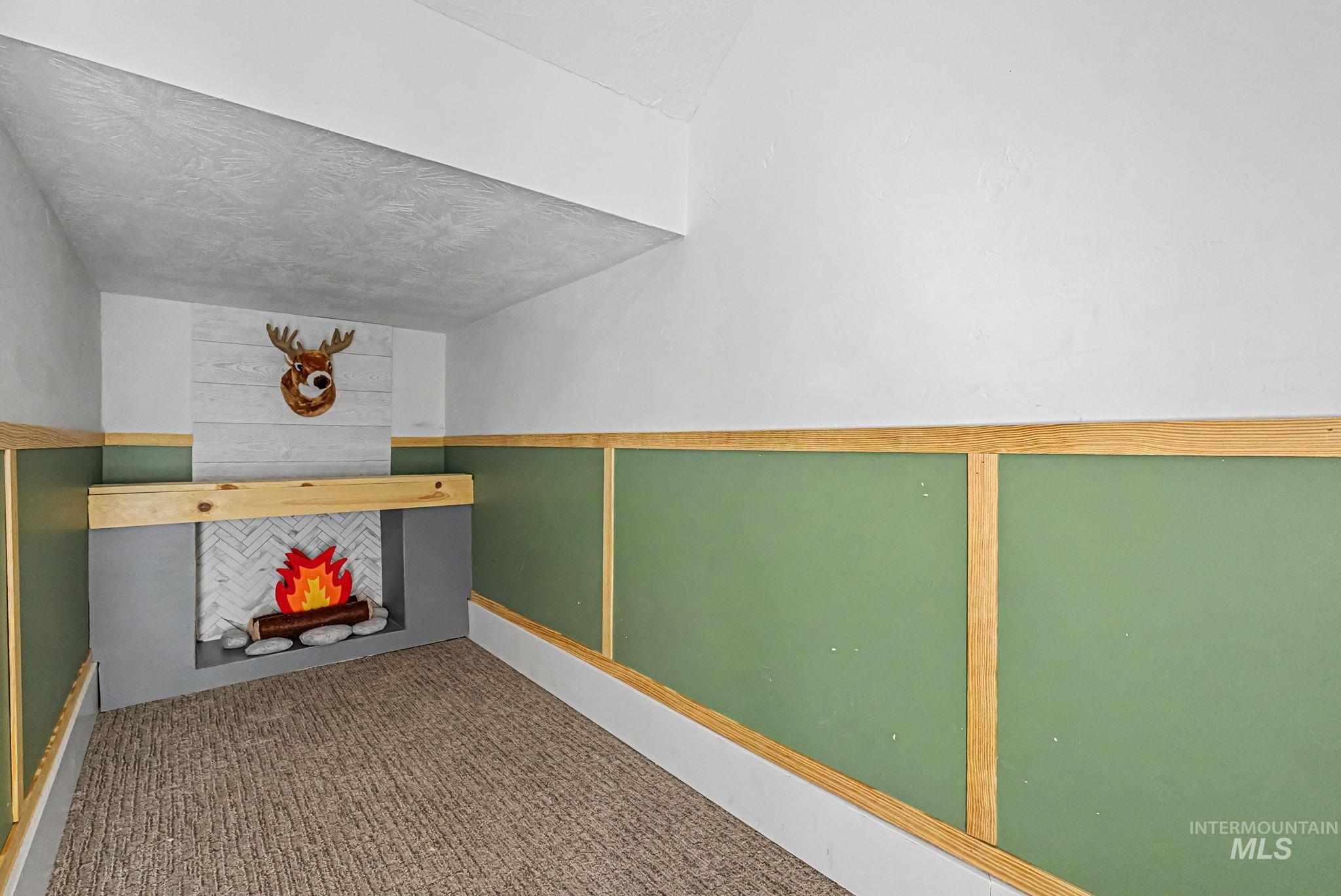 6521 South Pemberley Way Meridian, ID 83642 - Photo 7 of 42 Built-in decorative fireplace with herringbone tile surround, a wood mantel, and gray base