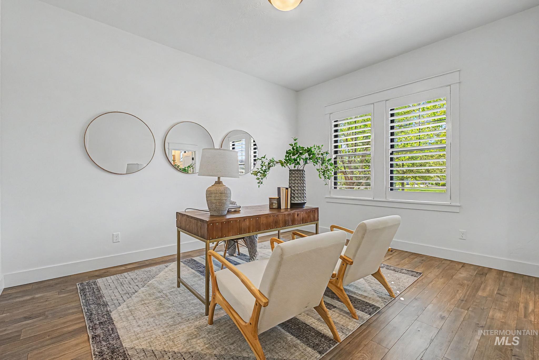 6521 South Pemberley Way Meridian, ID 83642 - Photo 8 of 42 Bright room featuring wood-finish flooring, white walls, and a window with plantation shutters
