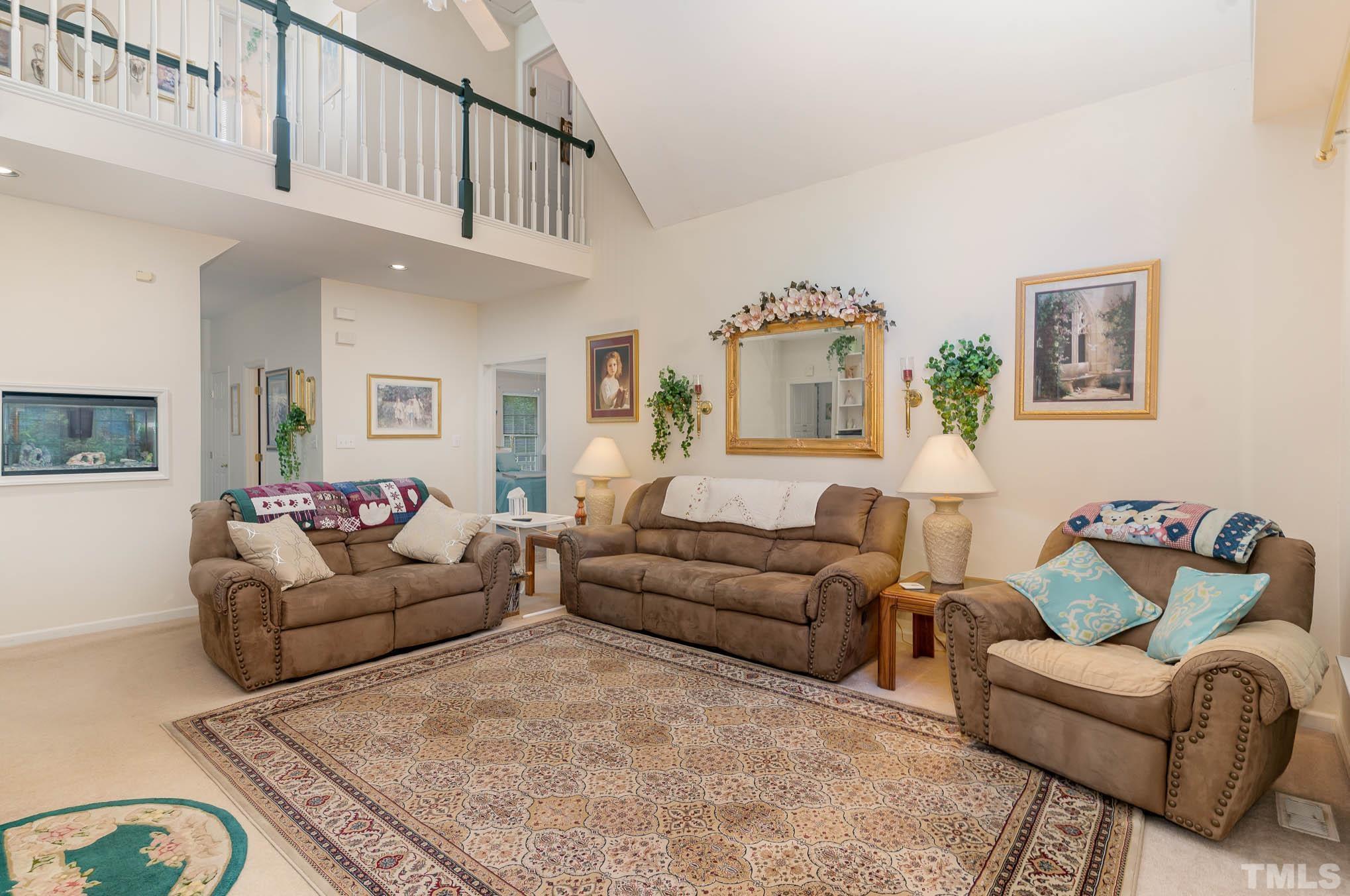 6913 Pinnacle Ridge Road Raleigh, NC 27603 - Photo 9 of 34 a living room with furniture a couch and paintings on the wall