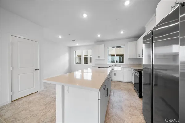 a kitchen with kitchen island a sink stainless steel appliances and cabinets