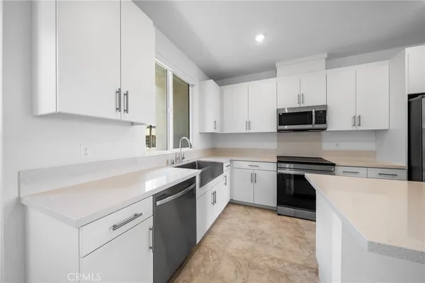 a kitchen with cabinets appliances a sink and a counter top space