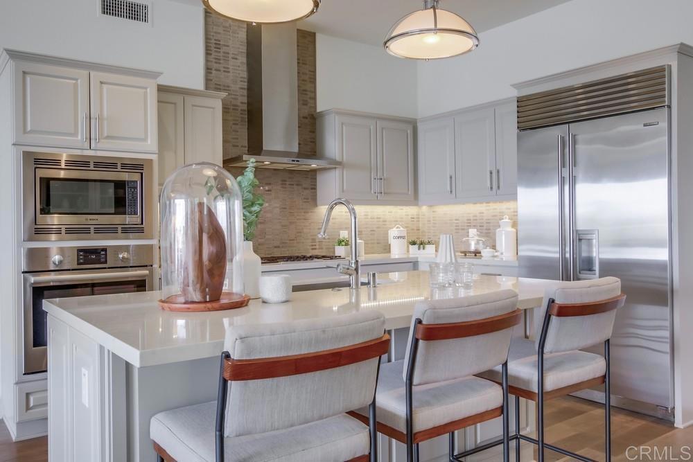 2333 Ocean Street Carlsbad, CA 92008 - Photo 7 of 67 a kitchen with kitchen island granite countertop a table chairs microwave and cabinets