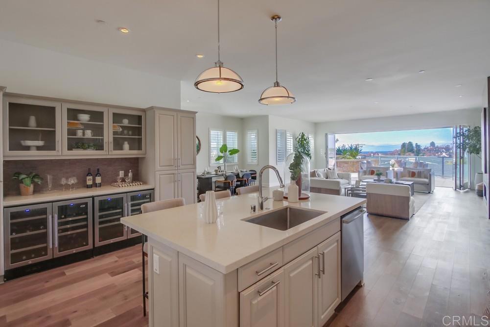 2333 Ocean Street Carlsbad, CA 92008 - Photo 9 of 67 a kitchen with stove a sink and dishwasher with wooden floor