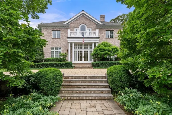 a front view of a house with a yard and trees