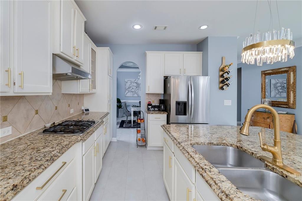 6810 Rocking Horse Lane Cumming, GA 30040 - Photo 11 of 39 a kitchen with granite countertop a sink stainless steel appliances and cabinets