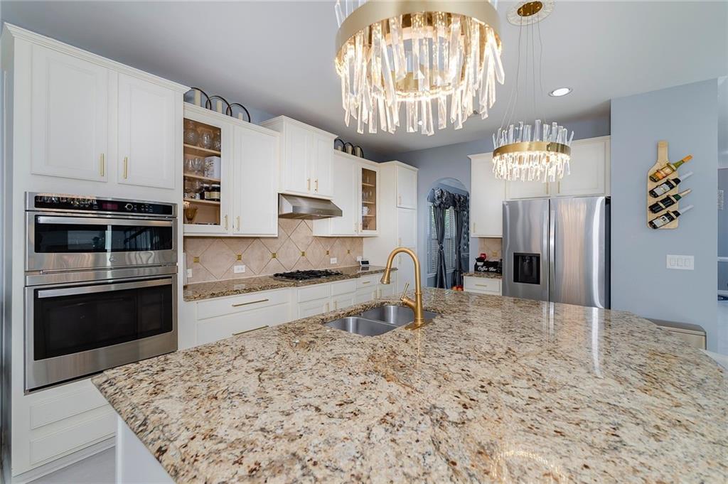 6810 Rocking Horse Lane Cumming, GA 30040 - Photo 15 of 39 a view of a kitchen with kitchen island granite countertop stainless steel appliances a stove refrigerator sink and cabinets