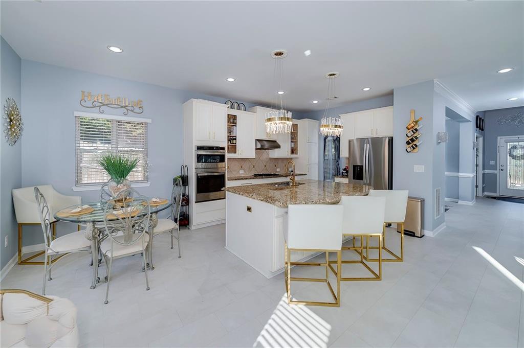 6810 Rocking Horse Lane Cumming, GA 30040 - Photo 16 of 39 a room with stainless steel appliances kitchen island granite countertop furniture and a view of kitchen