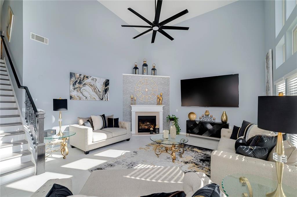 6810 Rocking Horse Lane Cumming, GA 30040 - Photo 17 of 39 a living room with furniture a flat screen tv and a fireplace