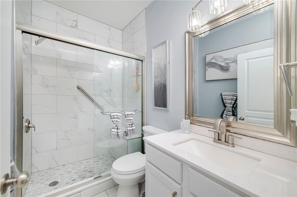 6810 Rocking Horse Lane Cumming, GA 30040 - Photo 21 of 39 a bathroom with a sink a toilet and shower