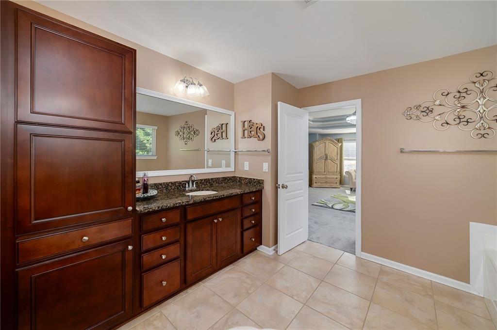 6810 Rocking Horse Lane Cumming, GA 30040 - Photo 25 of 39 a kitchen with granite countertop a refrigerator and a stove