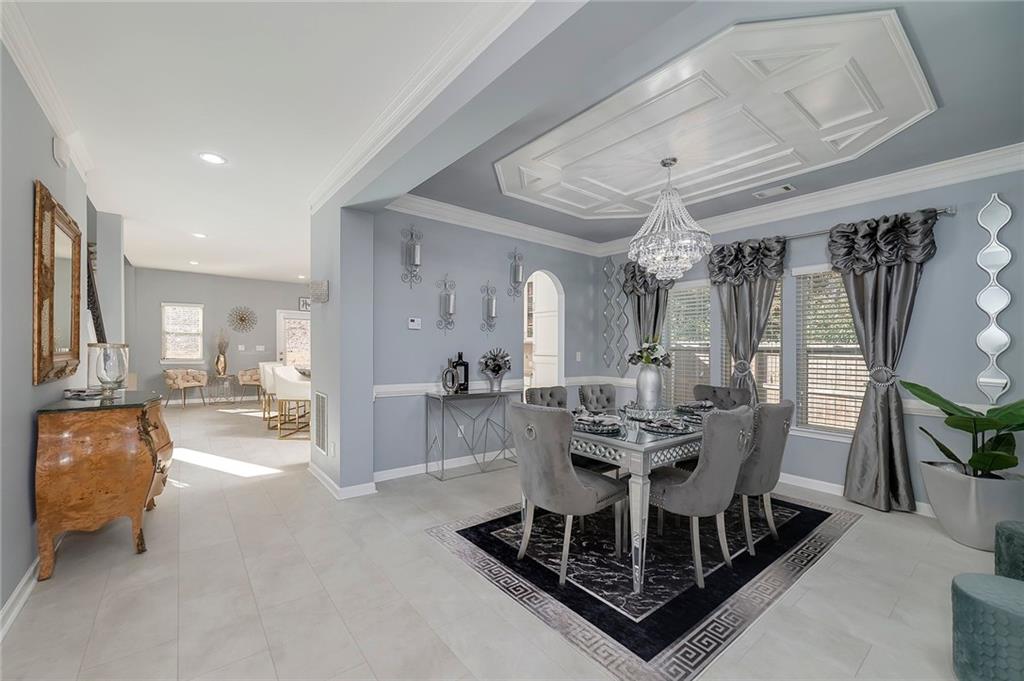 6810 Rocking Horse Lane Cumming, GA 30040 - Photo 7 of 39 a dining room with furniture a rug and a chandelier