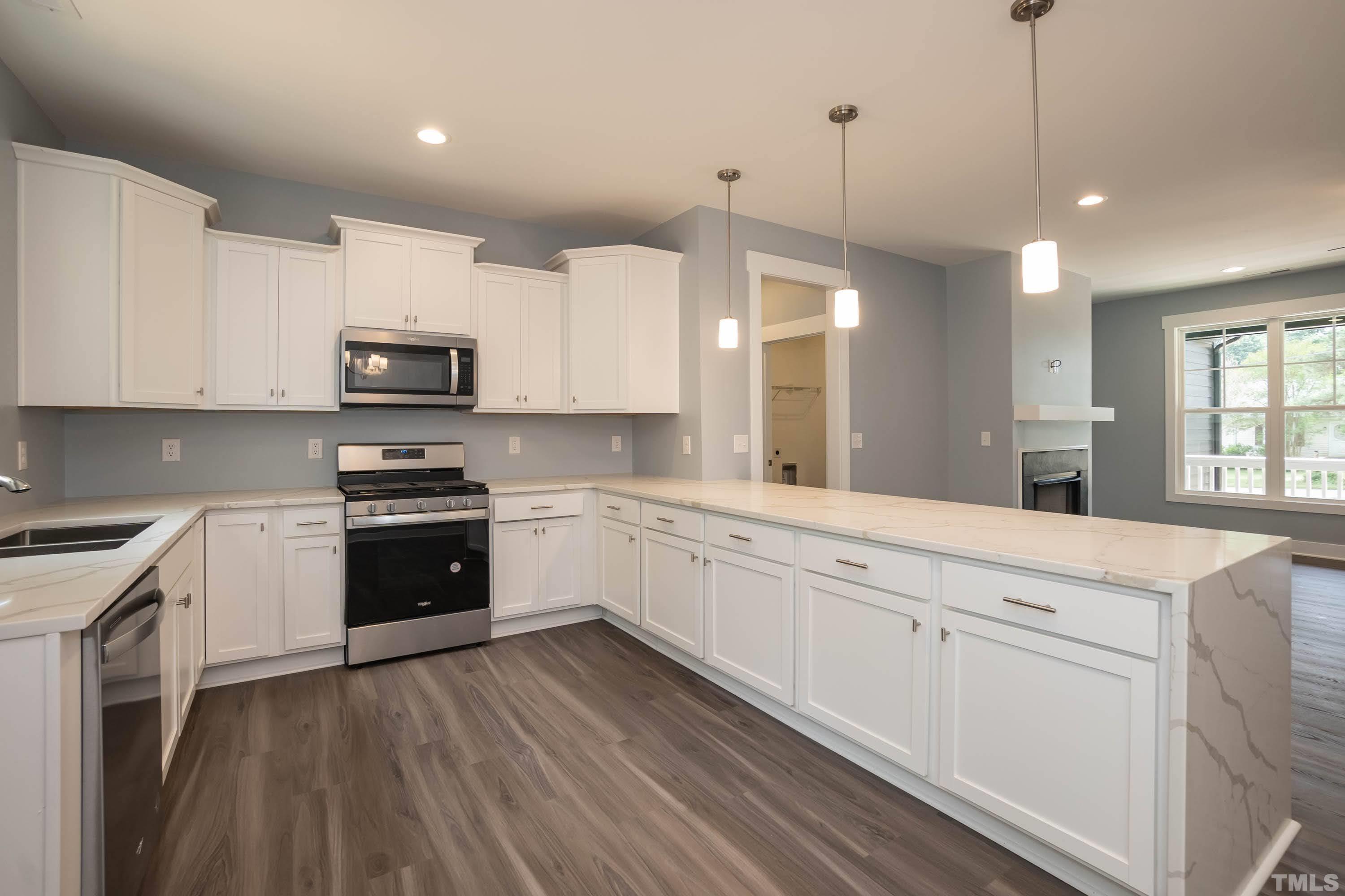 1701 Honeysuckle Road Raleigh, NC 27609 - Photo 11 of 29 a kitchen with kitchen island granite countertop a stove a sink and a microwave