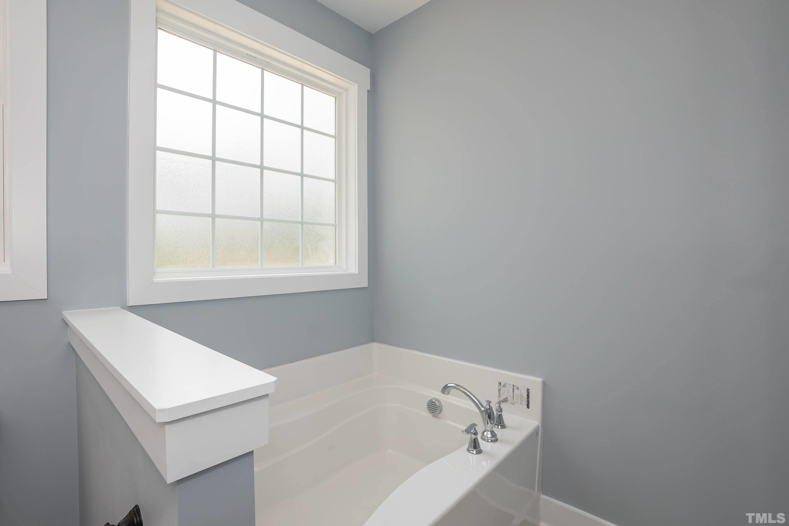 1701 Honeysuckle Road Raleigh, NC 27609 - Photo 18 of 29 a bathroom with a bathtub and window