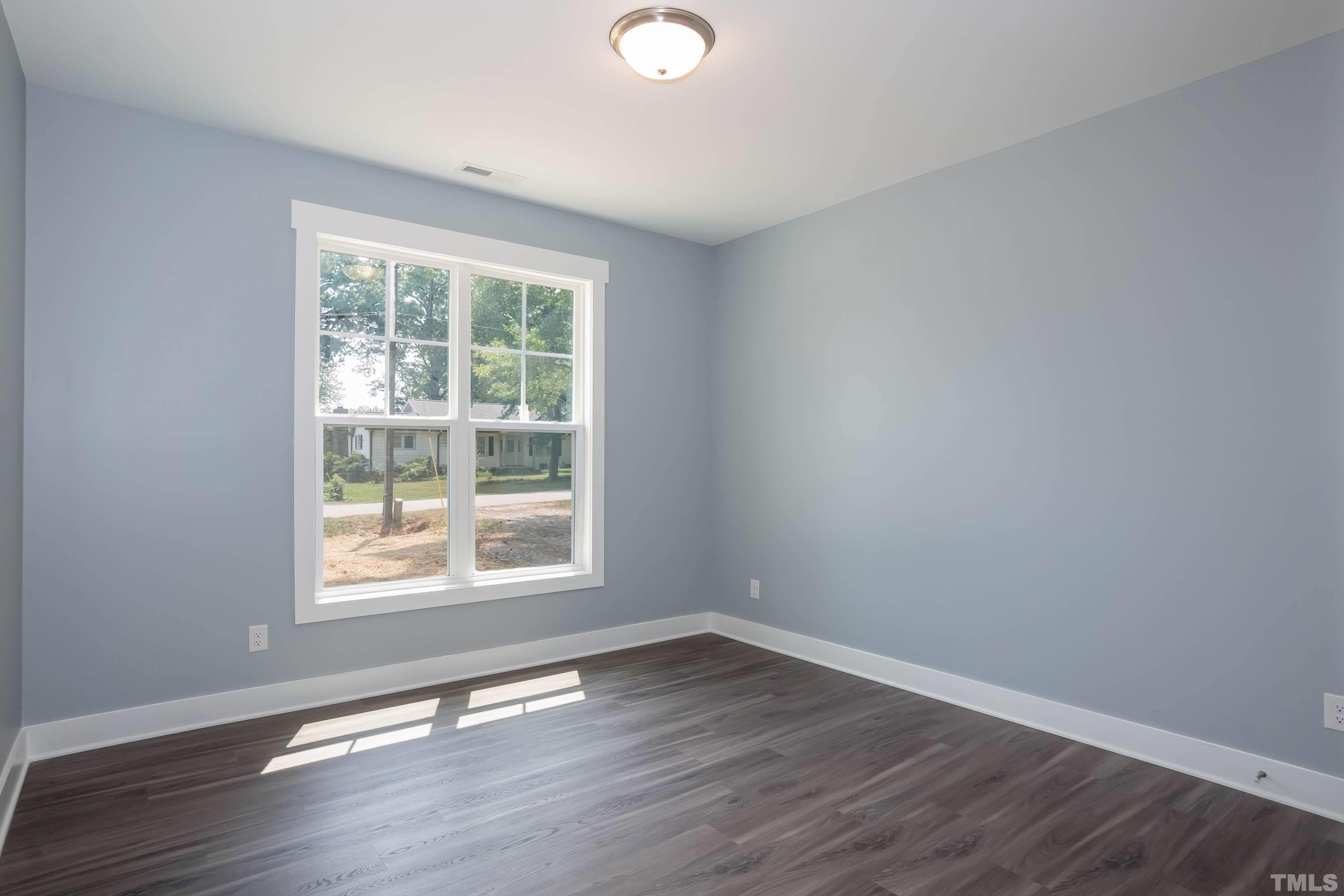 1701 Honeysuckle Road Raleigh, NC 27609 - Photo 21 of 29 a view of an empty room with wooden floor and a window