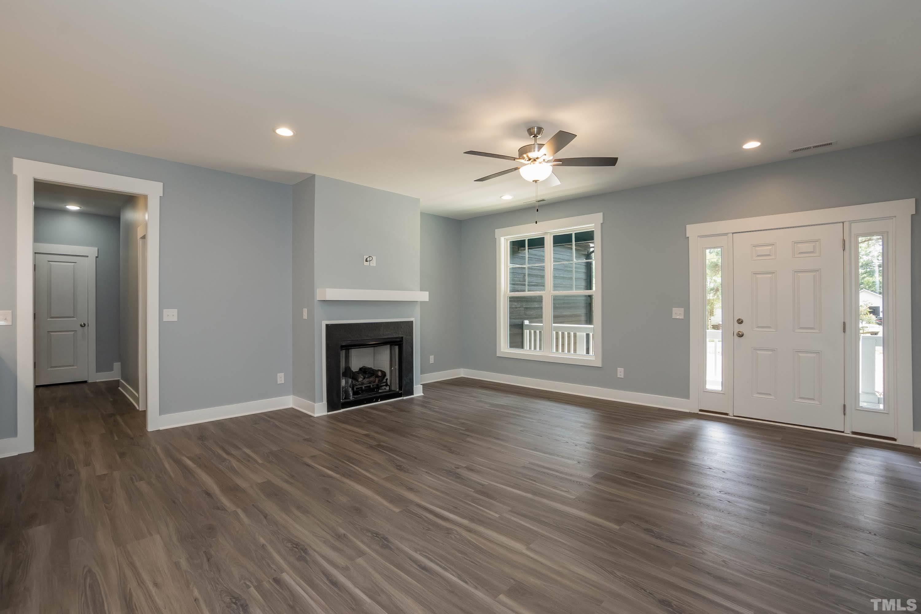 1701 Honeysuckle Road Raleigh, NC 27609 - Photo 6 of 29 an empty room with wooden floor fireplace and windows