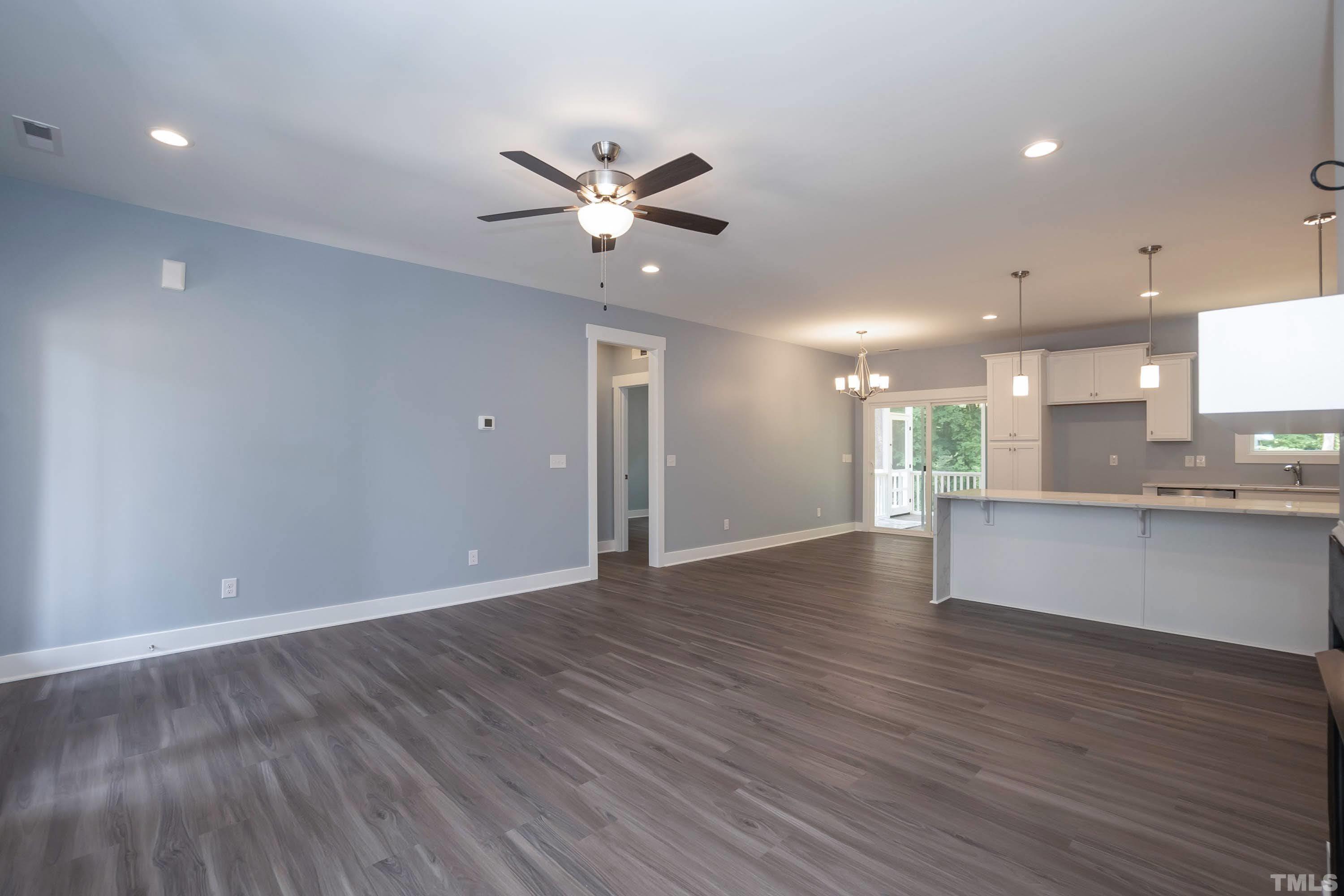 1701 Honeysuckle Road Raleigh, NC 27609 - Photo 8 of 29 a view of an empty room with wooden floor and a kitchen