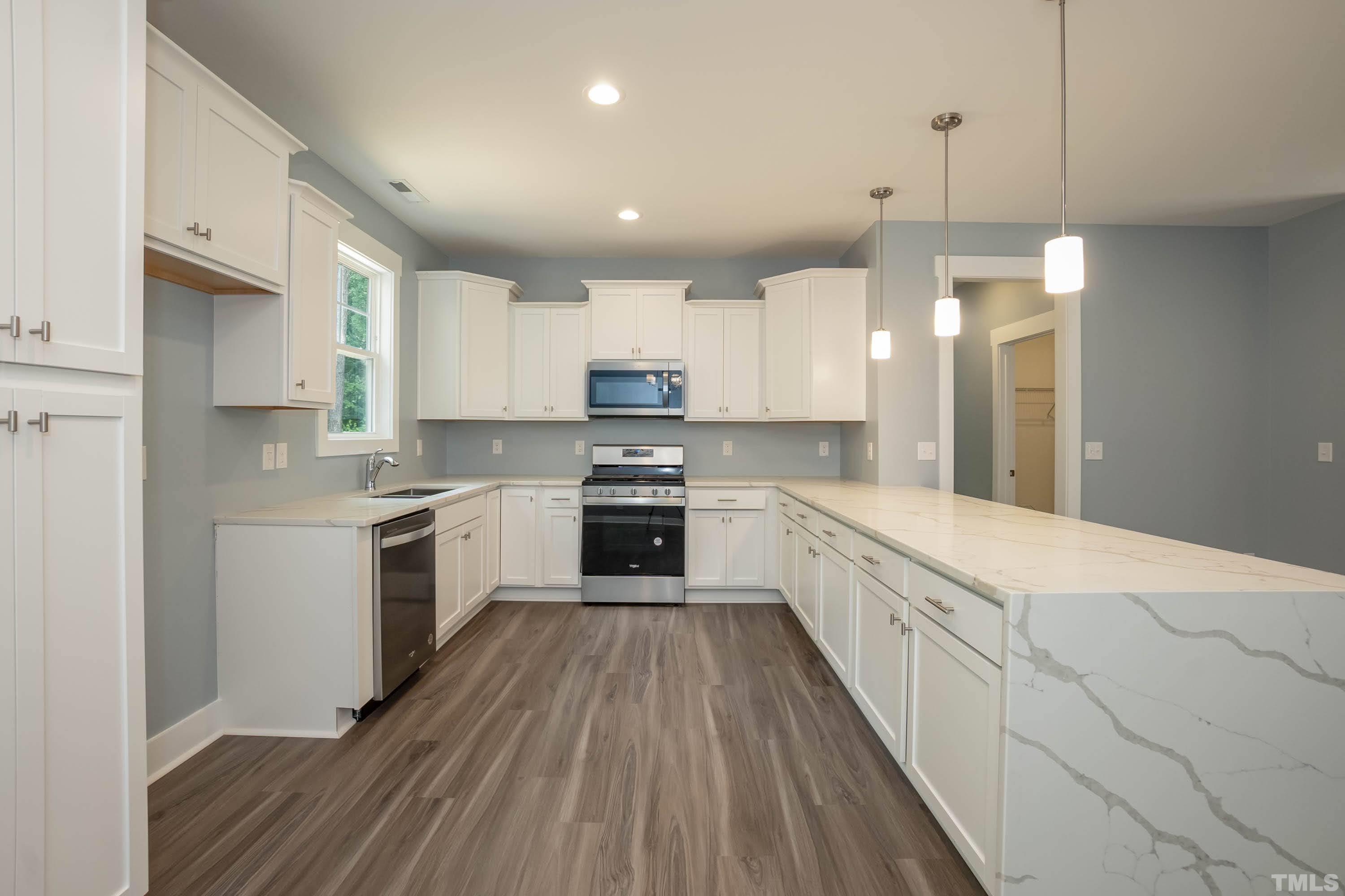 1701 Honeysuckle Road Raleigh, NC 27609 - Photo 10 of 29 a large kitchen with cabinets wooden floor and stainless steel appliances