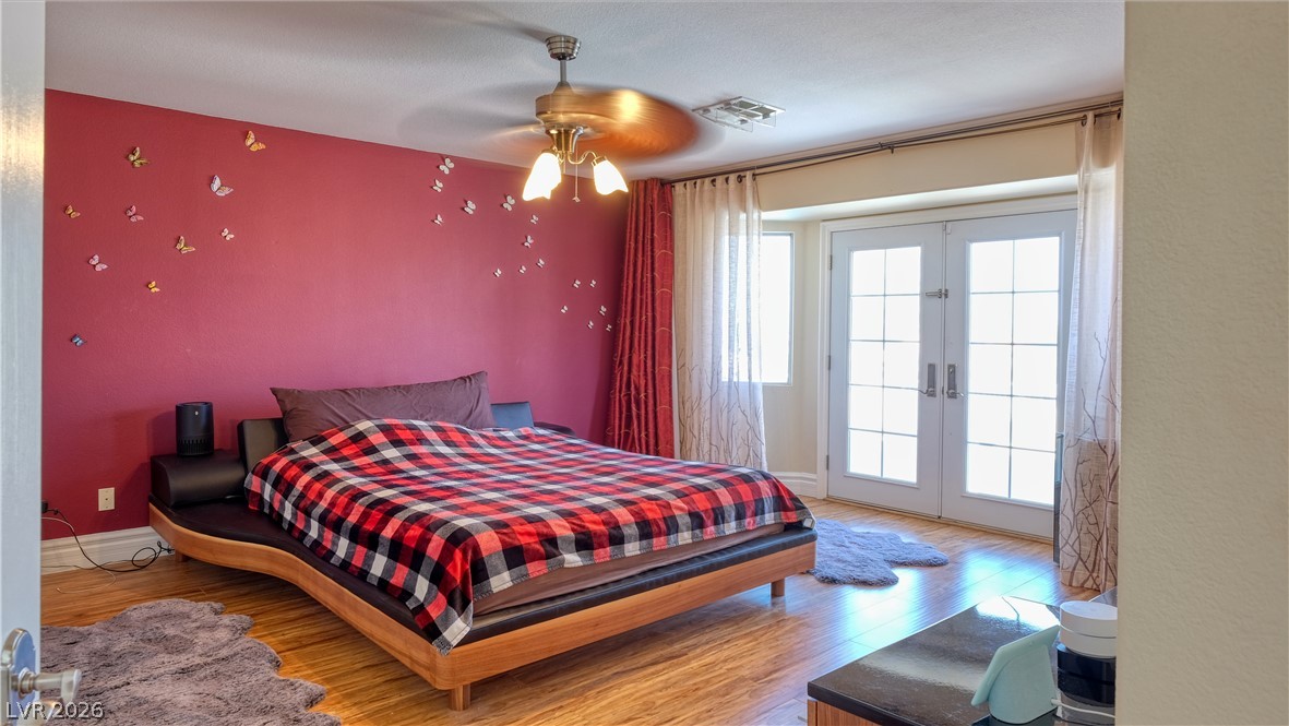 3704 North Campbell Road Las Vegas, NV 89129 - Photo 28 of 38 French doors open to an inviting bedroom with rich hardwood floors.