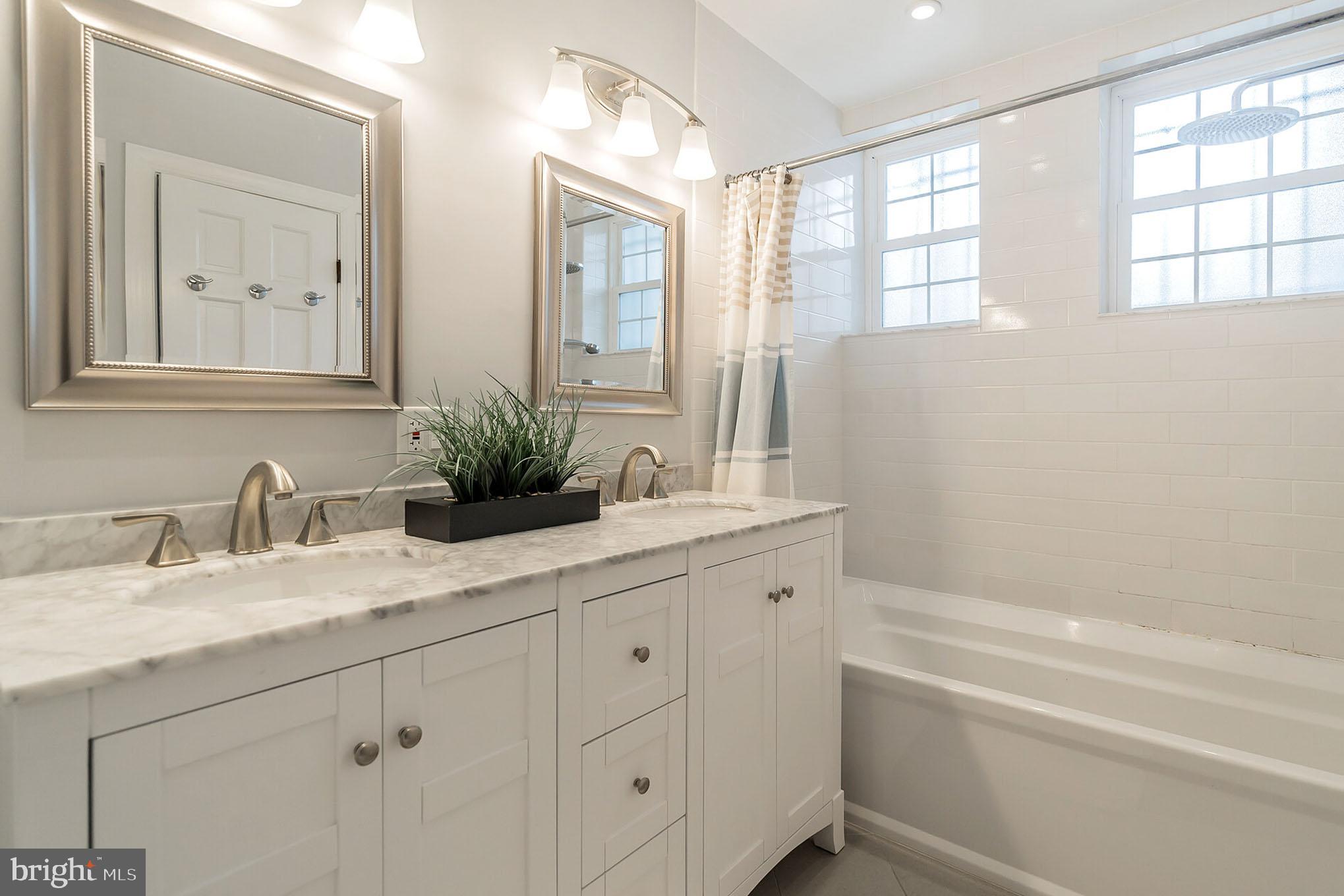 1754 Willard Street Northwest, Unit 2 Washington, DC 20009 - Photo 12 of 28 a bathroom with a granite countertop sink mirror and a bathtub