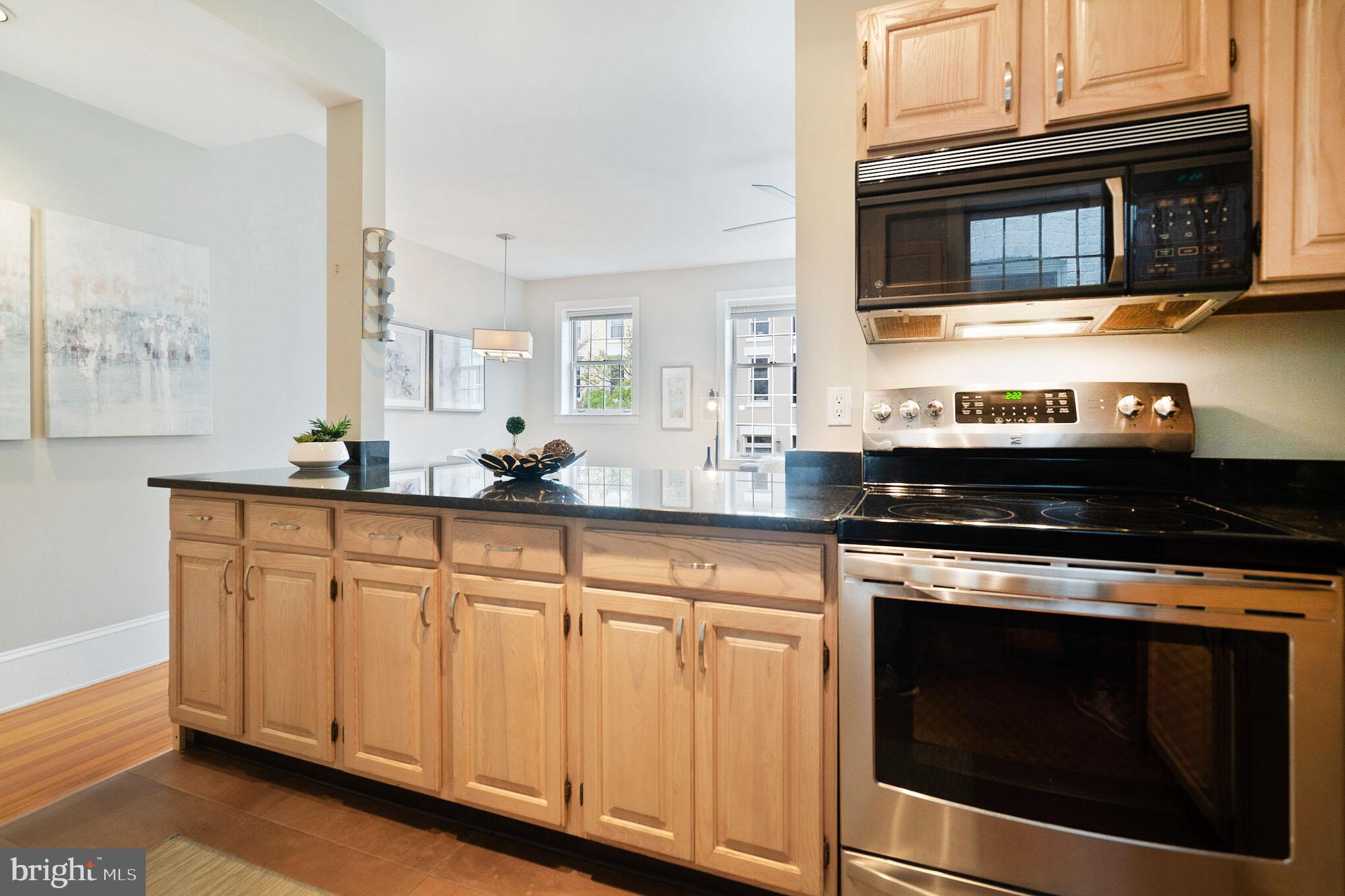 1754 Willard Street Northwest, Unit 2 Washington, DC 20009 - Photo 6 of 28 a kitchen with granite countertop cabinets stainless steel appliances and wooden floor