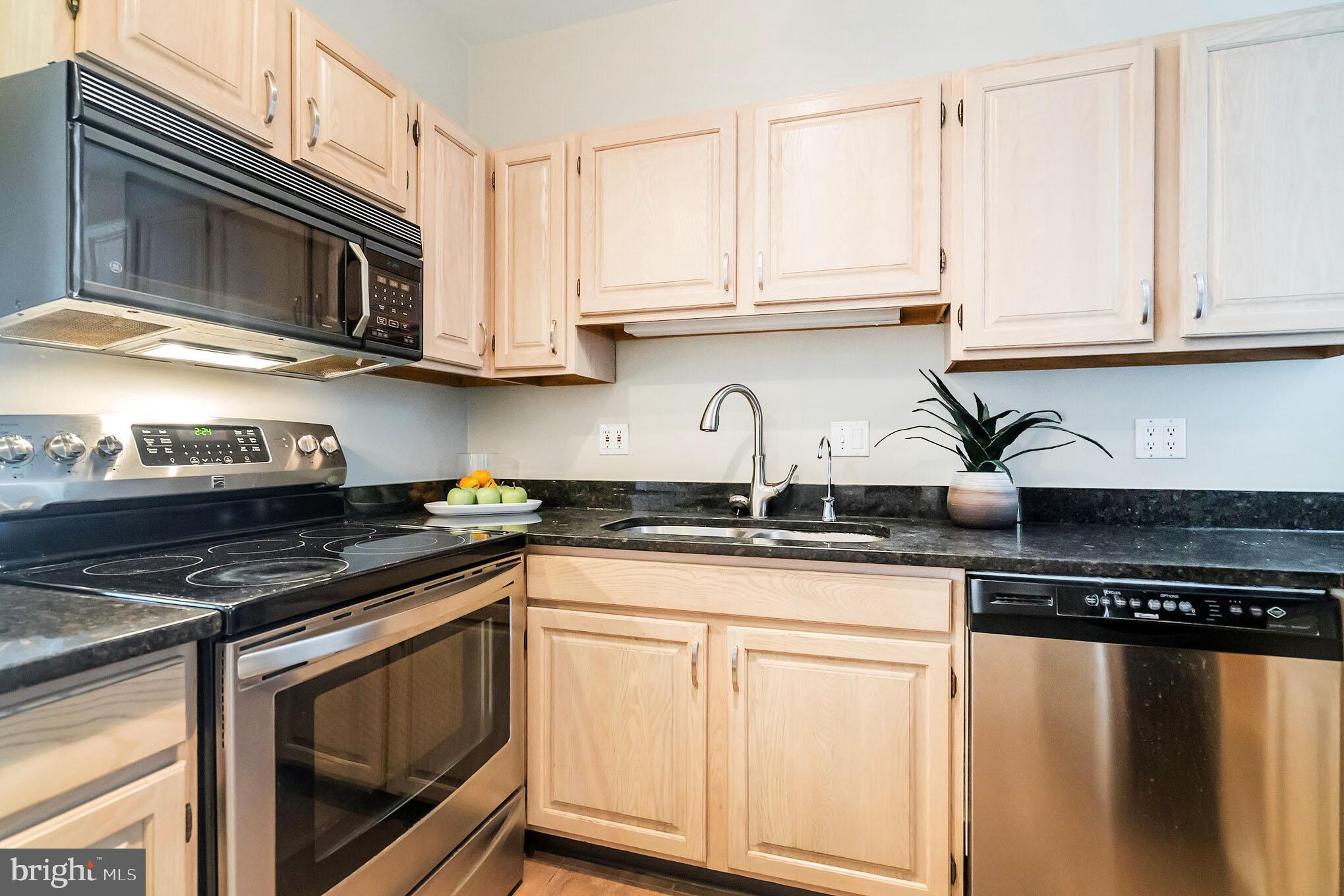 1754 Willard Street Northwest, Unit 2 Washington, DC 20009 - Photo 7 of 28 a kitchen with stainless steel appliances granite countertop a stove and a microwave