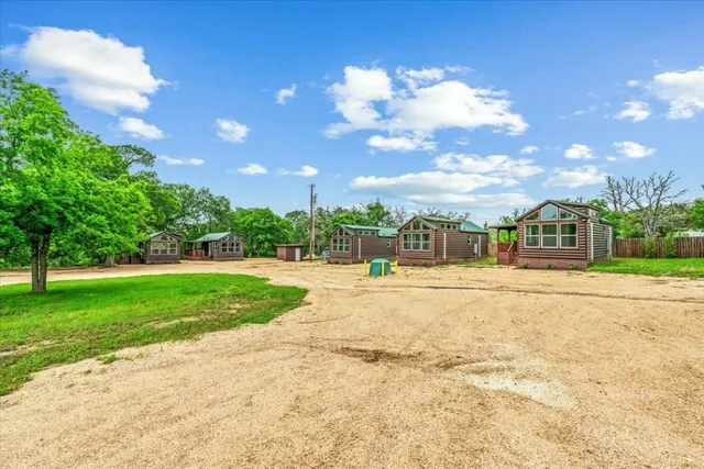 a view of a house with a big yard and a large tree