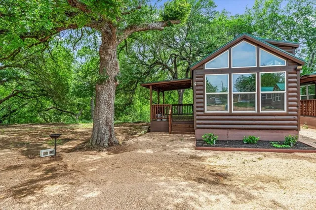 a view of a house with a yard and large tree