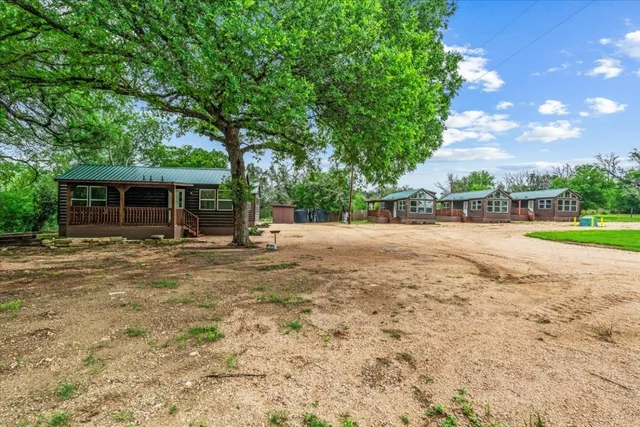 a view of a house with backyard and a tree