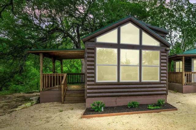 a view of a house with a yard and large tree