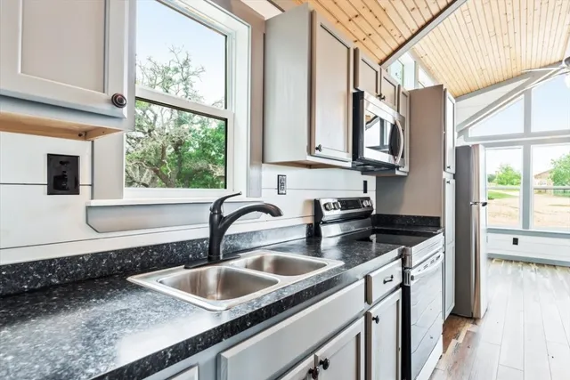 a kitchen with granite countertop a sink and a window