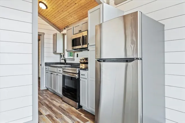 a kitchen with stainless steel appliances a refrigerator sink and white cabinets