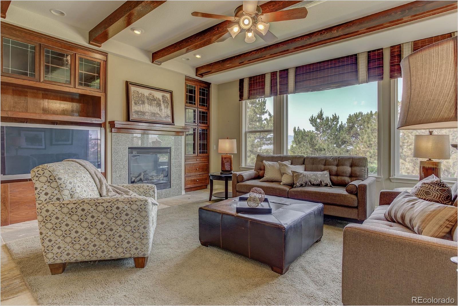 9061 Hunters Way Highlands Ranch, CO 80129 - Photo 12 of 33 a living room with furniture fireplace and a large window