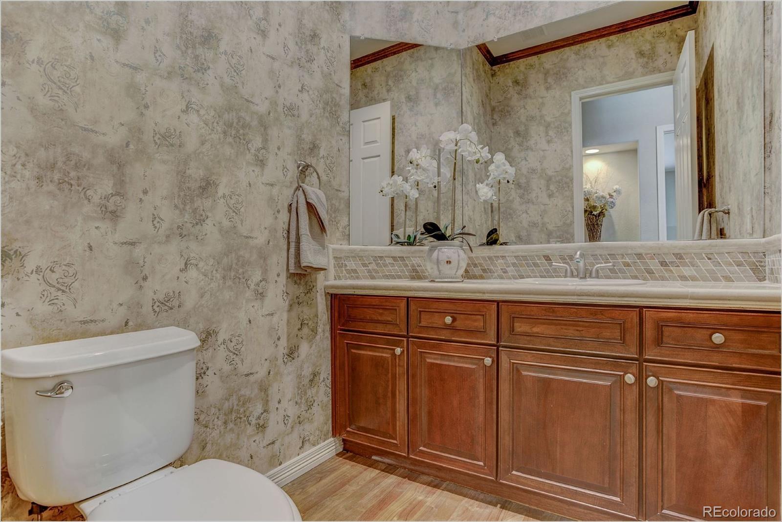 9061 Hunters Way Highlands Ranch, CO 80129 - Photo 19 of 33 a bathroom with a granite countertop sink and a mirror