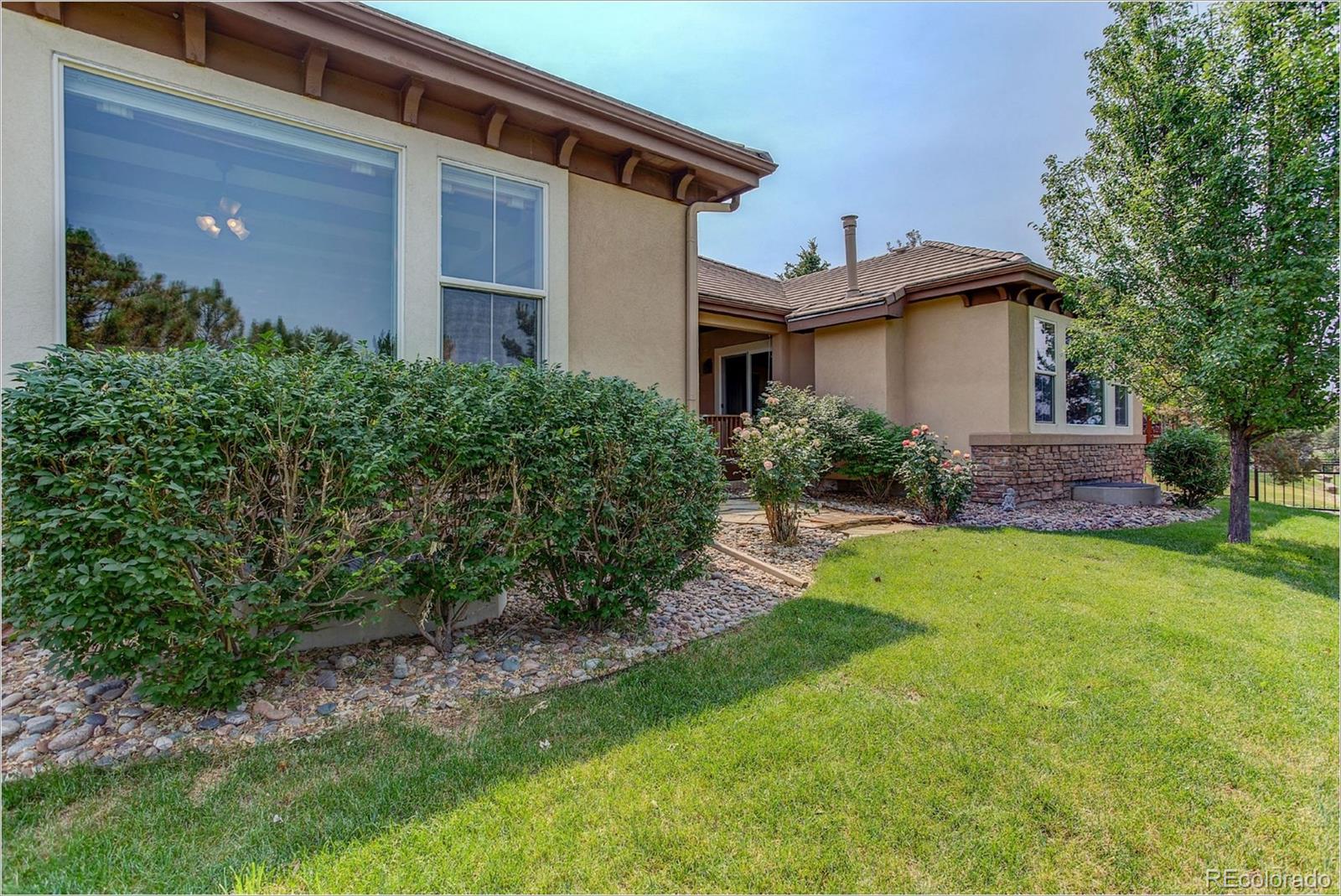 9061 Hunters Way Highlands Ranch, CO 80129 - Photo 30 of 33 a front view of a house with a yard and porch