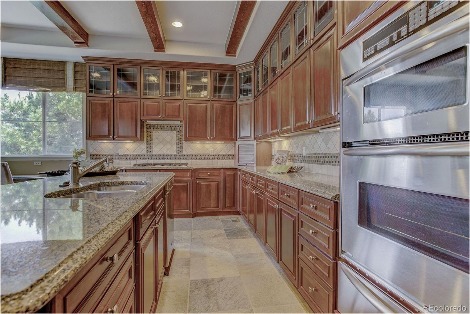 9061 Hunters Way Highlands Ranch, CO 80129 - Photo 4 of 33 a kitchen with stainless steel appliances granite countertop a sink a stove and a refrigerator